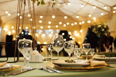 Açık hava düğün restoranı. Taze çiçekler ve özel yemeklerle süslenmiş. Çiçekli ve lambalı konuklar için masalar.