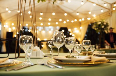 Açık hava düğün restoranı. Taze çiçekler ve özel yemeklerle süslenmiş. Çiçekli ve lambalı konuklar için masalar.