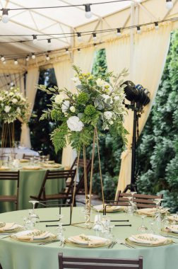 Lüks bir restoranda masanın üstünde güzel bir vazo çiçek. Düğün süslemeleri.