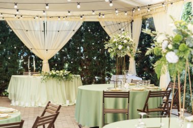 Lüks bir restoranda masanın üstünde güzel bir vazo çiçek. Düğün süslemeleri.