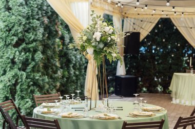 Lüks bir restoranda masanın üstünde güzel bir vazo çiçek. Düğün süslemeleri.