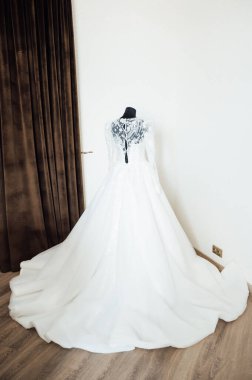 Kahverengi arka planda işlemeli ve dantelli modern bir gelinlik. Efendinin elinden yapılmış..