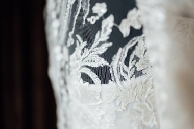 Kahverengi arka planda işlemeli ve dantelli modern bir gelinlik. Efendinin elinden yapılmış..