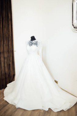 Beyaz arka planda işlemeli ve dantelli modern bir gelinlik. Efendinin elinden yapılmış..