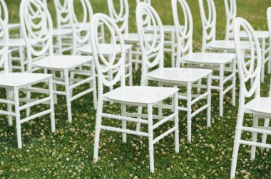 Düğün hazırlıkları için yeşil çimlerin yanında sandalyeler..