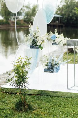 Nehir sahilinde düğün için açık havada bir yer. Yuvarlak kemerin büyük bir kurulumu. Düğün ayarları