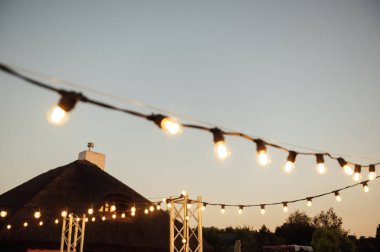 Düğün partisinde dekoratif lambalar. Akşam batımı.