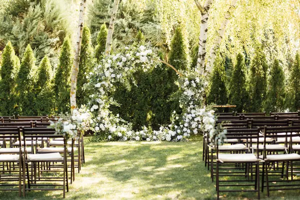 stock image Circle wedding arch decorated with white flowers and greenery outdoors. Wedding setting. Floral composition