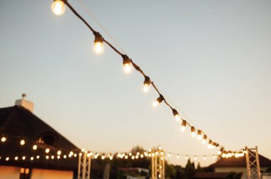 Düğün partisinde dekoratif lambalar. Akşam batımı.