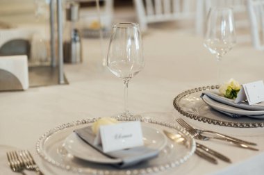 Bir restorandaki düğün yemeğinde konuklar için sofrada çatal bıçak ve tabaklar var..