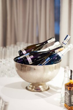 Buz kovasında bir şişe şampanya. Düğünde alkollü içecekler..