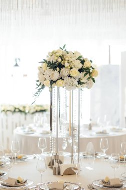 Lüks bir restoranda masanın üstünde güzel bir vazo çiçek. Düğün süslemeleri.