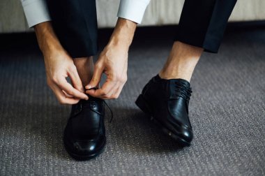 Siyah ayakkabılarını bağlayan bir adam. Yakın çekim görünümü