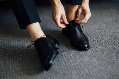 Siyah ayakkabılarını bağlayan bir adam. Yakın çekim görünümü