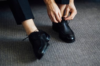 Siyah ayakkabılarını bağlayan bir adam. Yakın çekim görünümü