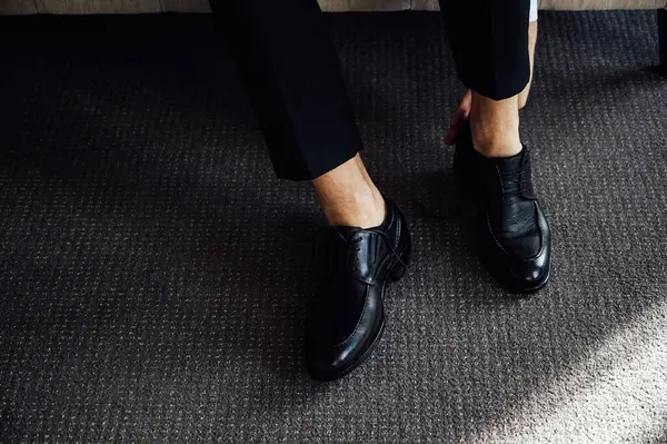 Siyah ayakkabılarını bağlayan bir adam. Yakın çekim görünümü