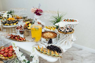 Masada konuklar için çok çeşitli atıştırmalıklar var. Karides, haşlanmış domuz eti, çeşitli et ve diğer ürünler..