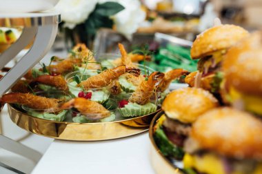 Masada konuklar için çok çeşitli atıştırmalıklar var. Karides, haşlanmış domuz eti, çeşitli et ve diğer ürünler..