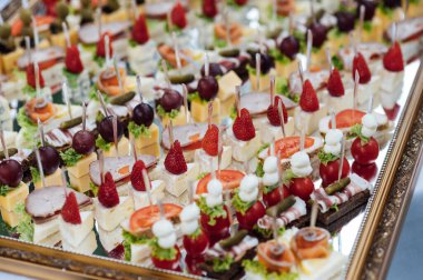 Ayna yüzeyindeki konuklar için geniş bir atıştırmalık koleksiyonu. Önemli bir olaydan önce açık büfe.