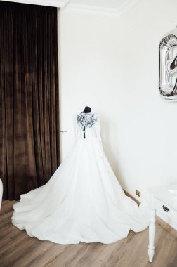 Kahverengi arka planda işlemeli ve dantelli modern bir gelinlik. Efendinin elinden yapılmış..