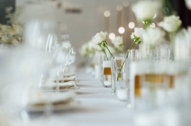 Zarif renksiz düğün masası manzarası çiçekler ve mumlarla.