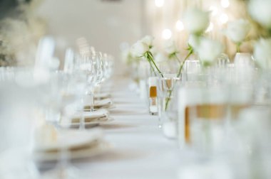 Zarif renksiz düğün masası manzarası çiçekler ve mumlarla.