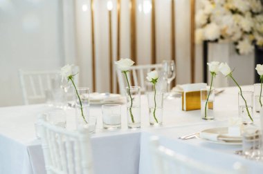 Zarif renksiz düğün masası manzarası çiçekler ve mumlarla.