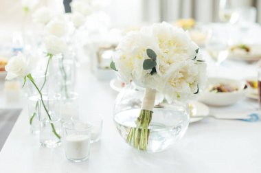 Zarif renksiz düğün masası manzarası çiçekler ve mumlarla.