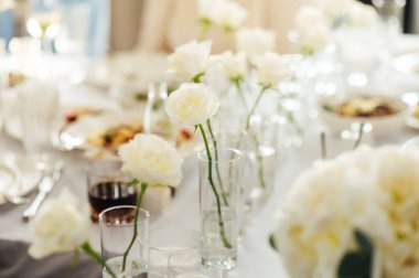 Zarif renksiz düğün masası manzarası çiçekler ve mumlarla.