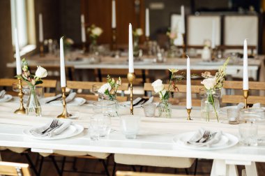 Zarif renksiz düğün masası manzarası çiçekler ve mumlarla.