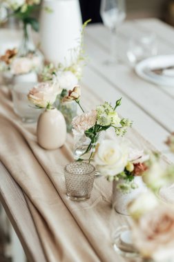 Zarif renksiz düğün masası manzarası çiçekler ve mumlarla.