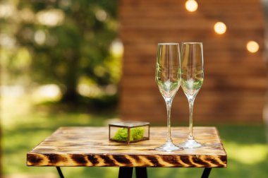 Yeni evliler için şampanya kadehleri tören kemerinin yanındaki masada duruyor..