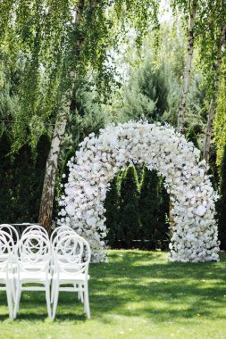 Düğün töreni. Çok güzel ve şık bir düğün kemeri, çeşitli taze çiçeklerle süslenmiş..