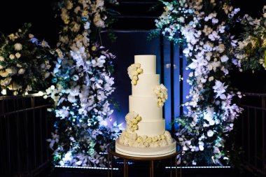 Akşam düğün kemerinin yanında güzel bir düğün pastası..