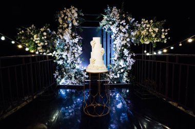 Akşam düğün kemerinin yanında güzel bir düğün pastası..