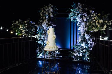 Akşam düğün kemerinin yanında güzel bir düğün pastası..