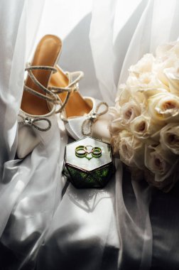 Gelinler düğün aksesuarları buket şeklinde, altın yüzükler ve ayakkabılar. Güzel parlak ayakkabılar ve düğün için bir buket