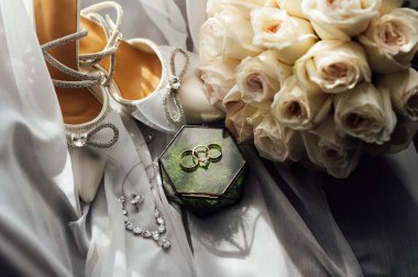 Gelinler düğün aksesuarları buket şeklinde, altın yüzükler ve ayakkabılar. Güzel parlak ayakkabılar ve düğün için bir buket