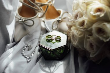 Gelinler düğün aksesuarları buket şeklinde, altın yüzükler ve ayakkabılar. Güzel parlak ayakkabılar ve düğün için bir buket