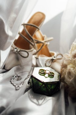 Gelinler düğün aksesuarları buket şeklinde, altın yüzükler ve ayakkabılar. Güzel parlak ayakkabılar ve düğün için bir buket