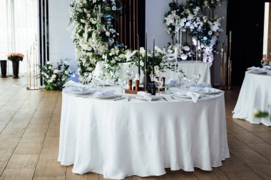 Lüks restoran. Lüks içecekler, beyaz masalar, misafirler için servis tabakları ve bardaklar..