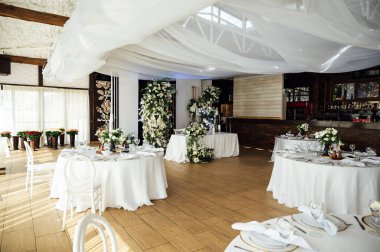 Lüks restoran. Lüks içecekler, beyaz masalar, misafirler için servis tabakları ve bardaklar..