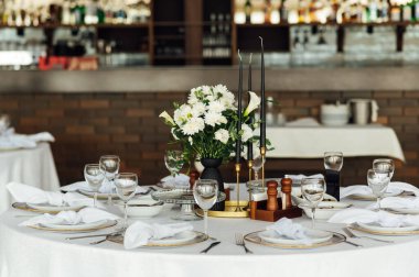 Lüks restoran. Lüks içecekler, beyaz masalar, misafirler için servis tabakları ve bardaklar..