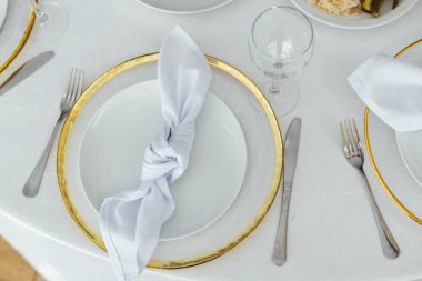 Lüks restoran. Lüks içecekler, beyaz masalar, misafirler için servis tabakları ve bardaklar..