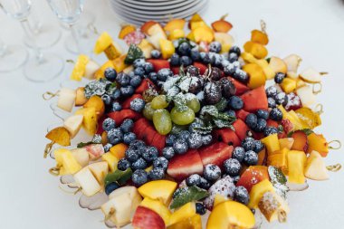 Düğün partisi. Sebze ve meyveli büfe masası. Etkinlikten önce açık büfede konuklar için geniş bir yiyecek seçimi ve çeşitli atıştırmalıklar.