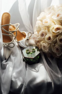 Gelinler düğün aksesuarları buket şeklinde, altın yüzükler ve ayakkabılar. Güzel parlak ayakkabılar ve düğün için bir buket