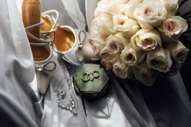 Gelinler düğün aksesuarları buket şeklinde, altın yüzükler ve ayakkabılar. Güzel parlak ayakkabılar ve düğün için bir buket