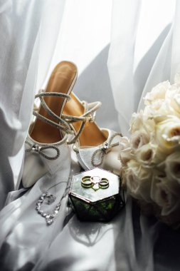 Gelinler düğün aksesuarları buket şeklinde, altın yüzükler ve ayakkabılar. Güzel parlak ayakkabılar ve düğün için bir buket