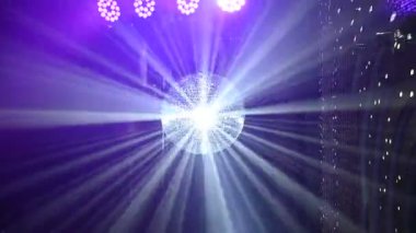 Aynalı bir disko topu ışık ışınlarını odanın her yerine yansıtır. Duman ışınların görünürlüğünü arttırır..