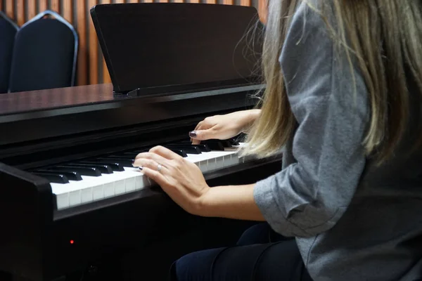 woman learning to play piano